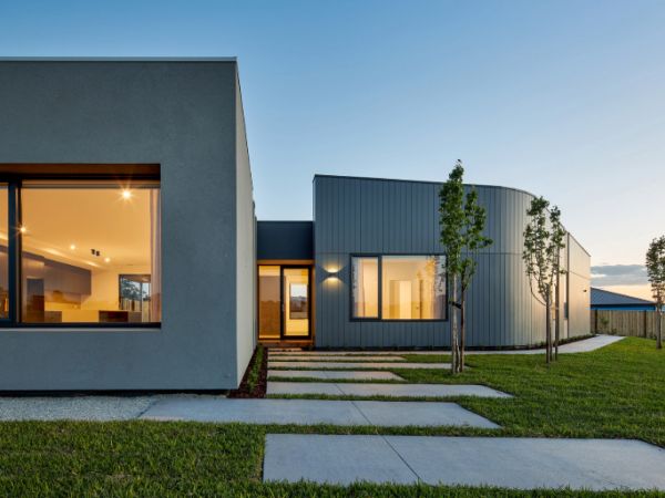 A modern house with a sleek architectural design, surrounded by a well-maintained Sir Walter DNA Certified Buffalo grass turf, enhancing the landscape.