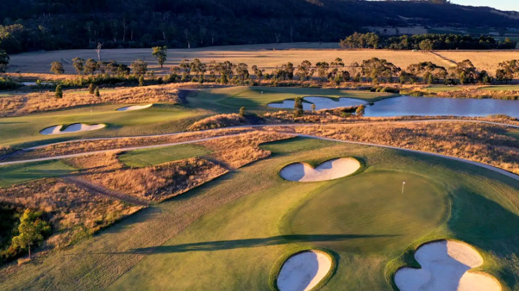 Aerial view of a landscaped golf course with greens, bunkers and water