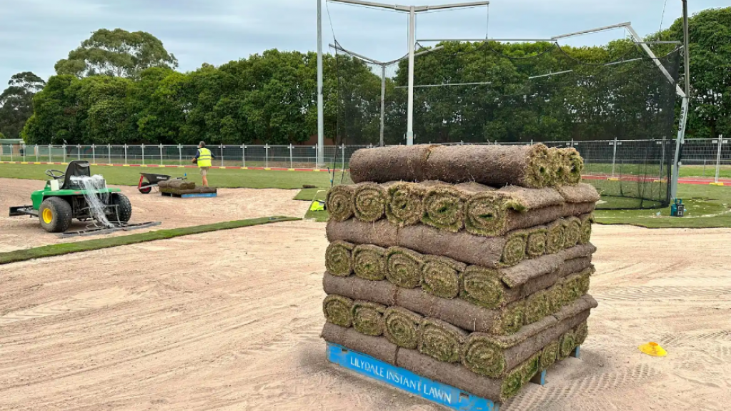 Rolled turf stacked on a pallet during sports field installation