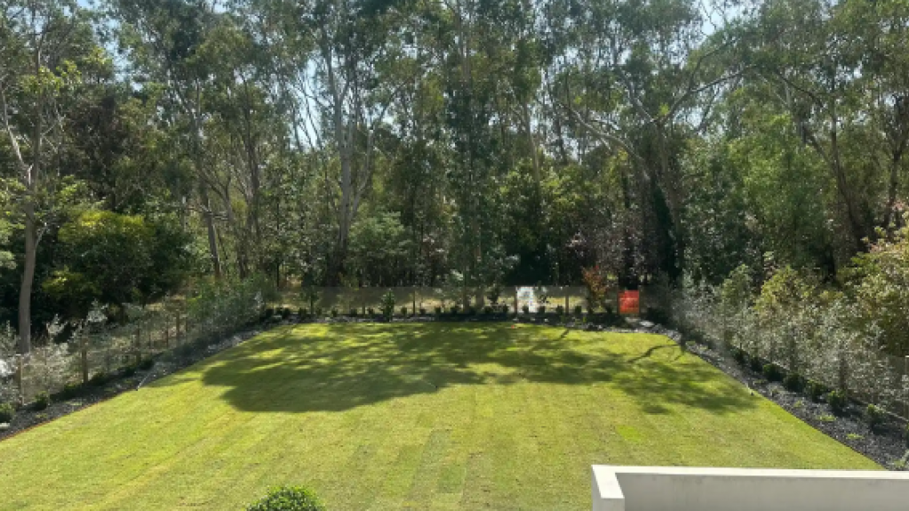 Backyard in Templestowe featuring newly laid Eureka Premium VG Kikuyu turf bordered by landscaped garden beds.