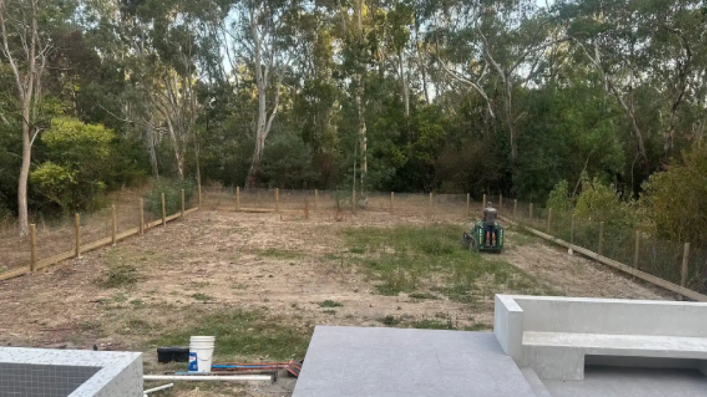 Templestowe backyard before Eureka Premium VG Kikuyu turf installation, showing uneven ground and sparse vegetation that required extensive soil preparation.