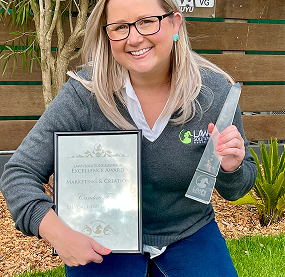 woman holding award and trophy